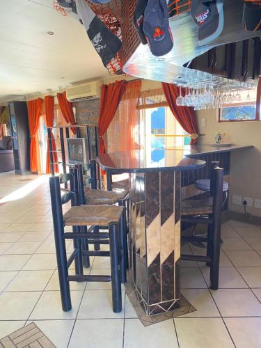 a bar with chairs and shoes hanging from the ceiling at The green room in Phalaborwa