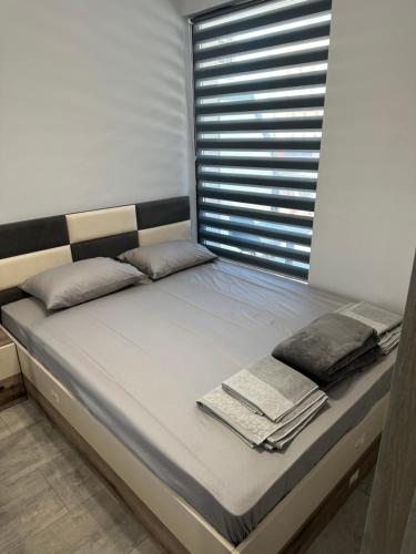 a bed with towels on it in a room with a window at Апартамент - Весела улица in Sozopol