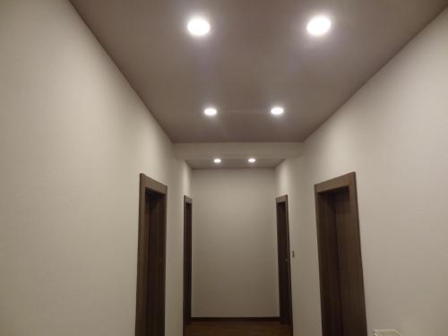a hallway with four doors and lights on a ceiling at Hotel GALENO - 3 Cime View - in Auronzo di Cadore