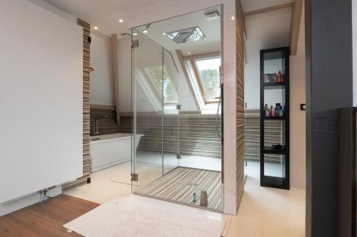 a bathroom with a glass shower and a sink at Chambre d'hôtes - Ty Castel in Ploeren