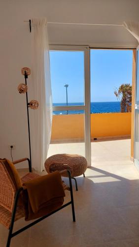 een kamer met een stoel en uitzicht op de oceaan bij La Marea Baja in Puertito de Güímar