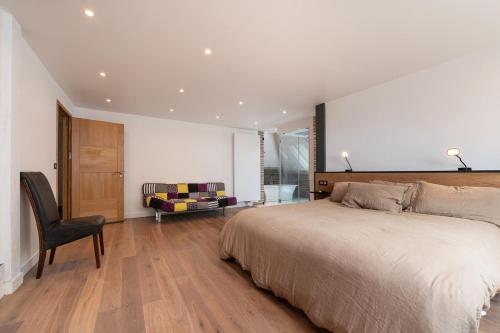 a bedroom with a large bed and a chair at Chambre d'hôtes - Ty Castel in Ploeren