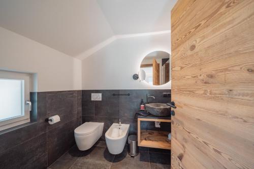 a bathroom with a white toilet and a sink at Apartments Hofmann in Prateria