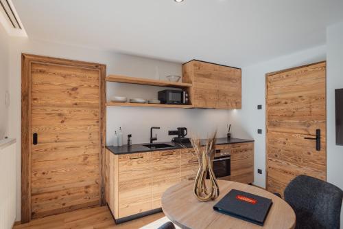 a kitchen with wooden doors and a table with a vase on it at Apartments Hofmann in Prateria
