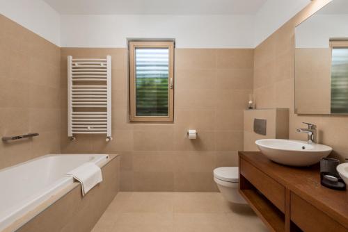 a bathroom with a tub and a toilet and a sink at Green Tree Villas in Rabac