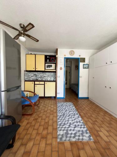 Il comprend un salon avec un ventilateur de plafond et une cuisine. dans l'établissement Cœur de Ville Appartement studio pour 5 personnes N125, à La Grande Motte