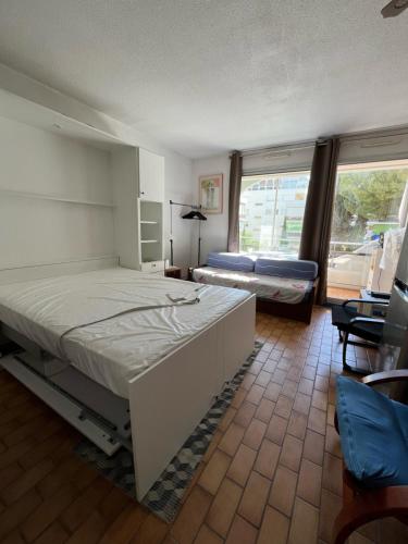 une chambre avec deux lits et une grande fenêtre dans l'établissement Cœur de Ville Appartement studio pour 5 personnes N125, à La Grande Motte