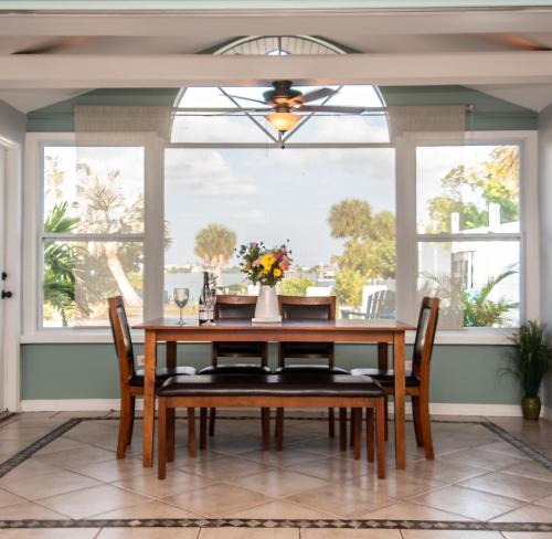 Un comedor con mesa y sillas y una gran ventana. en Paradise Cove on Lemon Bay, en Englewood