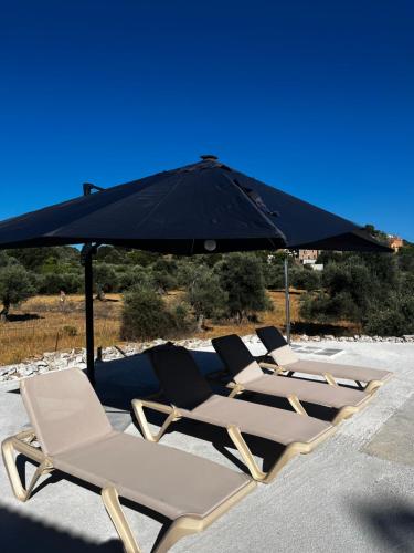 a row of lounge chairs under an umbrella at Pulchra Campis,Private Pool,Wifi,Parking in Nerokoúros
