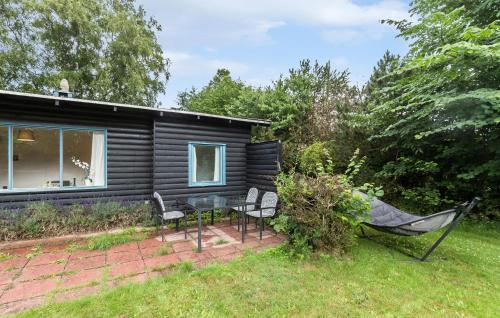 a black tiny house with a glass table and chairs at 3 Bedroom Amazing Home In Gilleleje in Gilleleje