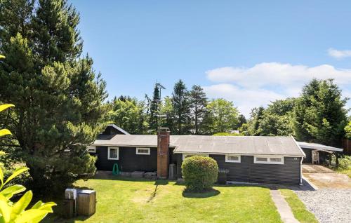 a small house with a garage in a yard at 4 Bedroom Stunning Home In Gilleleje in Gilleleje