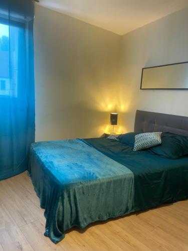 une chambre avec un grand lit avec une couverture bleue dans l'établissement GRAND STUDIO proche du centre ville, à Strasbourg