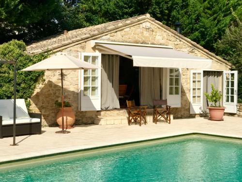 une maison avec une piscine et un parasol dans l'établissement Provence Monastery, à Althen-des-Paluds
