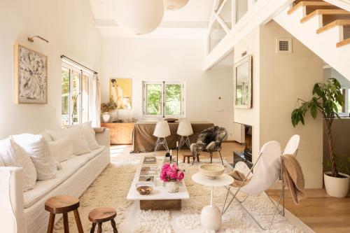 un salon avec un canapé blanc et des chaises dans l'établissement Chalet Hautbois - Family Chalet with 5 Bedrooms with Glacial views CHAMONIX - By Cozee Rentals, à Chamonix-Mont-Blanc