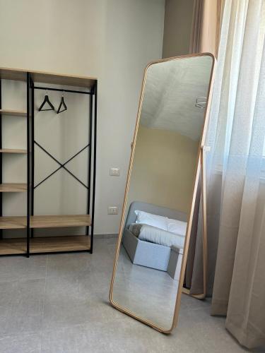 a mirror in a room with a bed and a closet at Il GrecAle - Camere e Appartamenti in La Morra