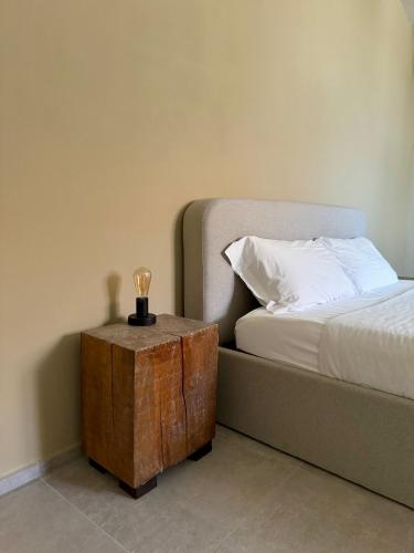 a bedroom with a bed and a wooden trunk next to a table at Il GrecAle - Camere e Appartamenti in La Morra