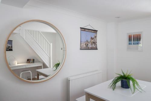 a white room with a mirror and a staircase at Typical English Terraced House in Brighton & Hove
