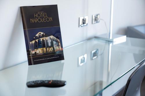a book sitting on a table next to a remote control at Hotel Napoleon in Torre Melissa