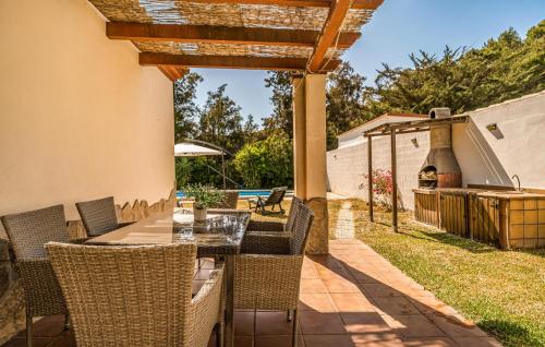 eine Terrasse mit einem Tisch, Stühlen und einem Grill in der Unterkunft Nice Home In Chiclana De La Fronter in Chiclana de la Frontera