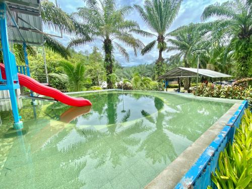 ein Schwimmbad mit Rutsche in einem Resort in der Unterkunft รรินธารา รีสอร์ท in Ban Bang Khan