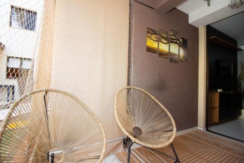two white fans sitting next to a wall at OZPED Flats Particulares Edifício Life Resort in Brasilia