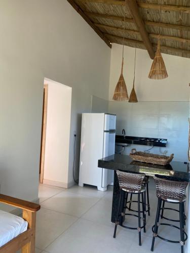 Una cocina con una mesa y dos sillas y un refrigerador. en Villa apartamentos, en Trancoso