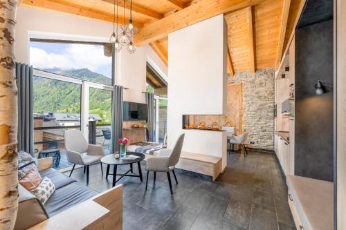 a kitchen and living room with a large window at 24 by AvenidA - Mountain Hotel in Kaprun