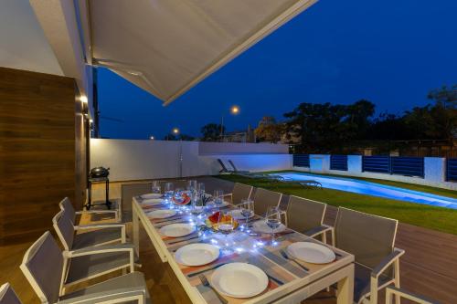 a long table with plates and wine glasses on it at Luxurious & Comfy by Fidalsa in El Campello