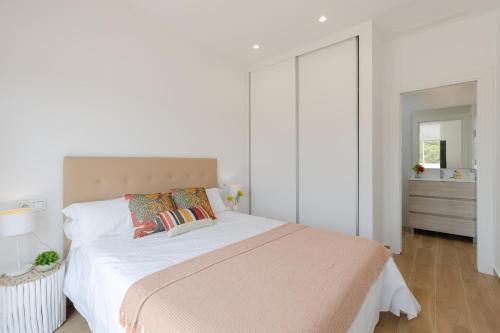 a white bedroom with a large bed with pillows at Luxurious & Comfy by Fidalsa in El Campello