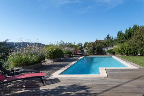 une piscine avec une chaise rose à côté dans l'établissement Logement spacieux agréable, à Saint-Privat