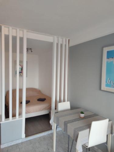 - une chambre avec un lit, une table et des chaises dans l'établissement Byblos studio vue mer, à Antibes