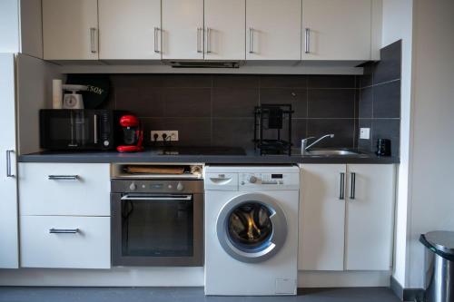 une cuisine avec une machine à laver et un évier dans l'établissement GuestReady - Tranquil City Haven in the Heart Nice, à Nice