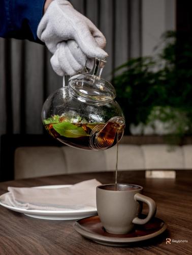 a person holding a fish in a glass bowl over a coffee cup at Badia Hill in Badia