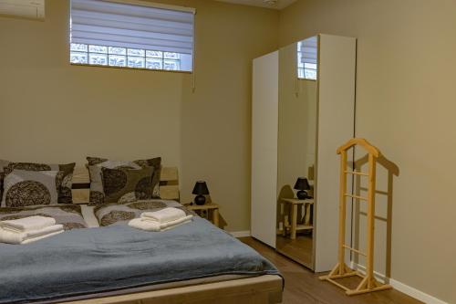 a bedroom with a bed and a window and a mirror at Szélcsengő Wellness Vendégház in Makó