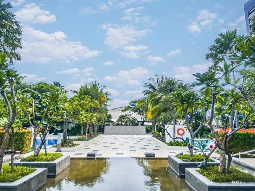 a courtyard with trees and a fountain in a building at Sophisticated 2BR Surabaya Apartment at Via Tower Ciputra World by Le Ciel Hospitality in Surabaya