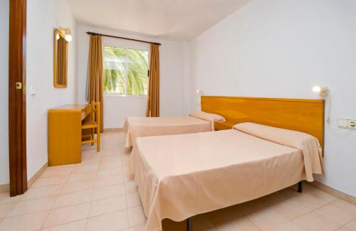 เตียงในห้องที่ Apartamentos Cala LLonga Playa