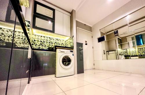 a laundry room with a washing machine in it at Sophisticated 2BR Surabaya Apartment at Via Tower Ciputra World by Le Ciel Hospitality in Surabaya
