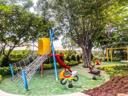 a park with a playground with a slide at Sophisticated 2BR Surabaya Apartment at Via Tower Ciputra World by Le Ciel Hospitality in Surabaya