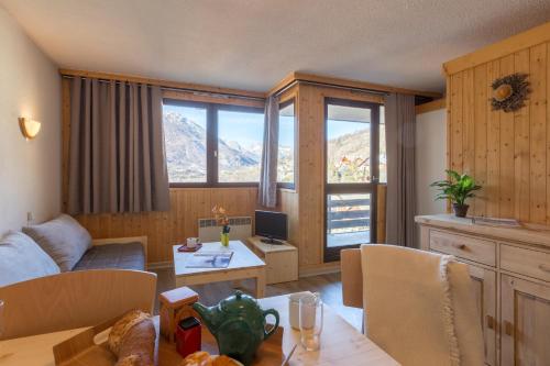 un salon avec un canapé et une table dans l'établissement Les Mélèzes, à Saint-Chaffrey