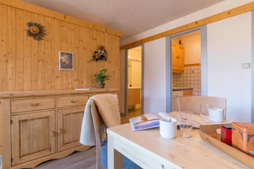 Un comedor con una mesa y una cocina. en Les Mélèzes, en Saint-Chaffrey