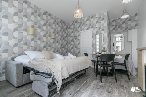 une chambre avec un lit et une table avec une chaise dans l'établissement MBA-Splendide Appart Wattignies, à Paris