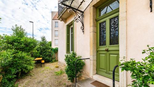 une porte verte sur le côté d'un bâtiment dans l'établissement Jade - Evasion vintage, à Dijon