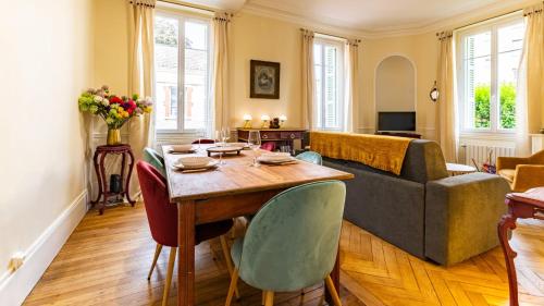 un salon avec une table et un canapé dans l'établissement Jade - Evasion vintage, à Dijon