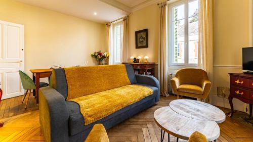 un salon avec un canapé et une table dans l'établissement Jade - Evasion vintage, à Dijon