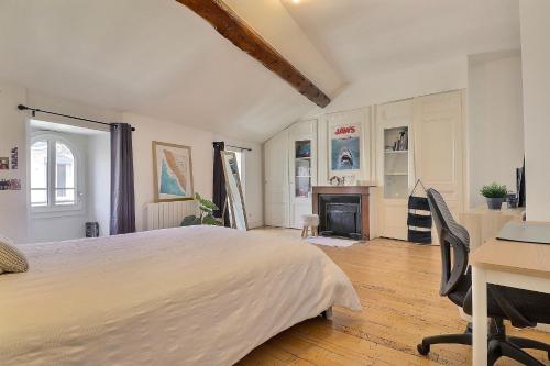 Un dormitorio con una cama, un escritorio y una chimenea. en Appartement d'exception plein centre, en Lyon
