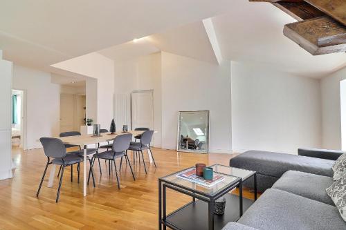 un salon avec un canapé, une table et des chaises dans l'établissement Appartement d'exception plein centre, à Lyon