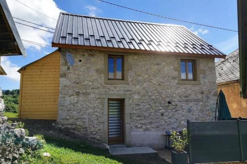 une maison en pierre avec un toit en métal dans l'établissement Charmante maison au désert d'Entremont, à Les Déserts