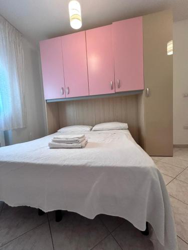 a bedroom with a large bed with pink cabinets at Residence San Martino in Busso