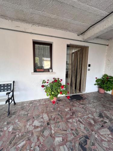 a room with a bench and a window and flowers at Residence San Martino in Busso