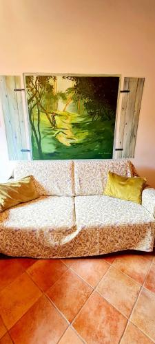 a couch in a room with a painting on the wall at Flat Ghino di Tacco historical centre Radicofani in Radicofani